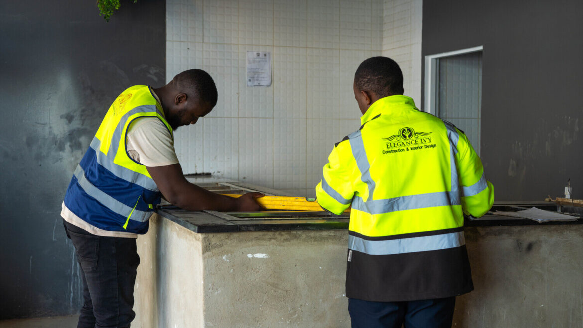 Two people in high-visibility workwear discussing work on site.